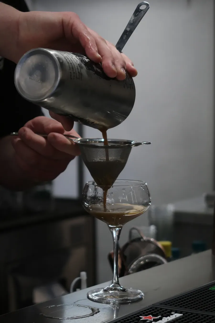 Barman che filtra un espresso martini nel bicchiere — immagine del sito Urban46.